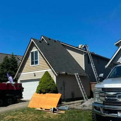 Residential roof installation in progress with ladders